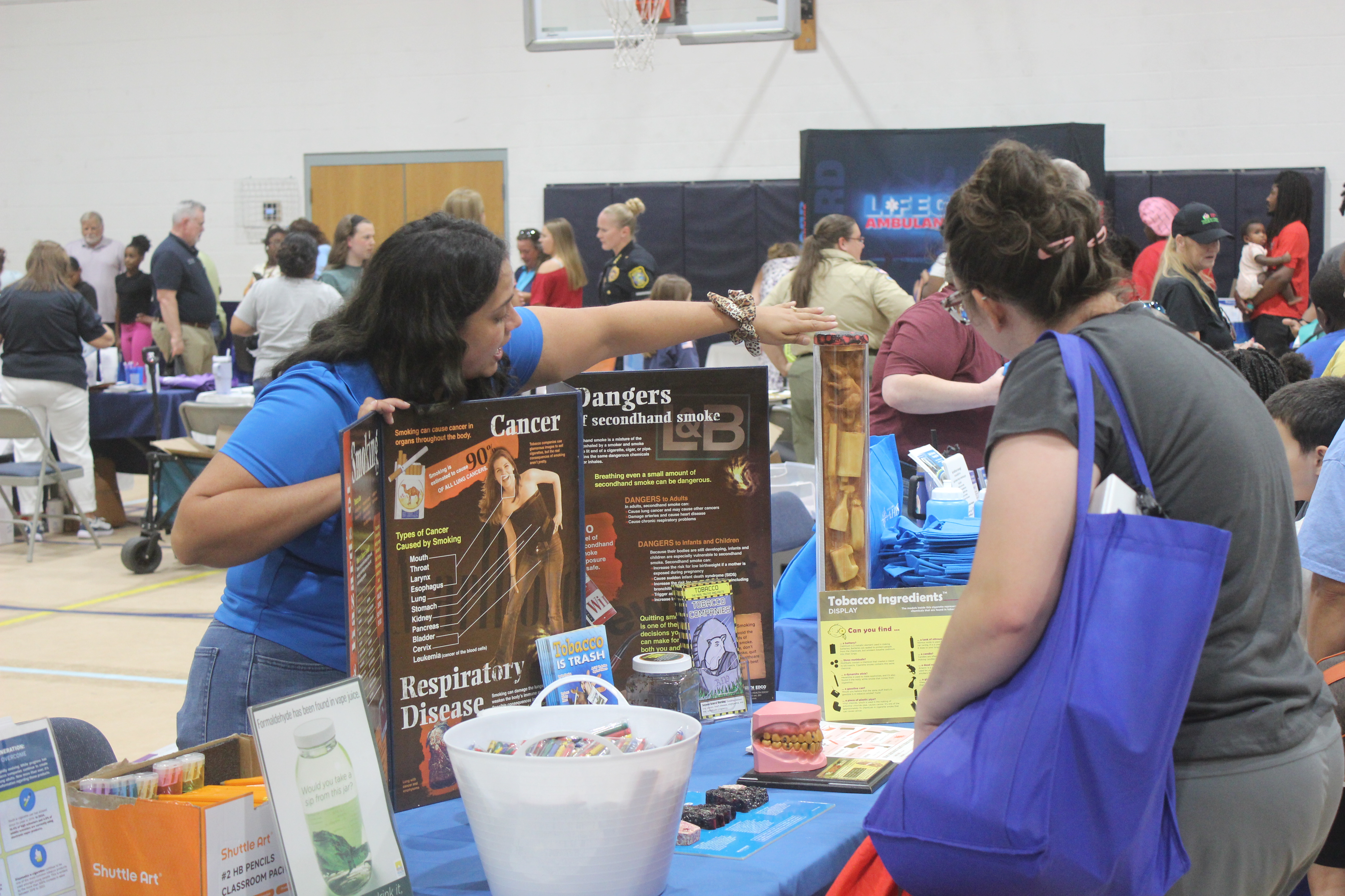 A woman points out a display to another woman.